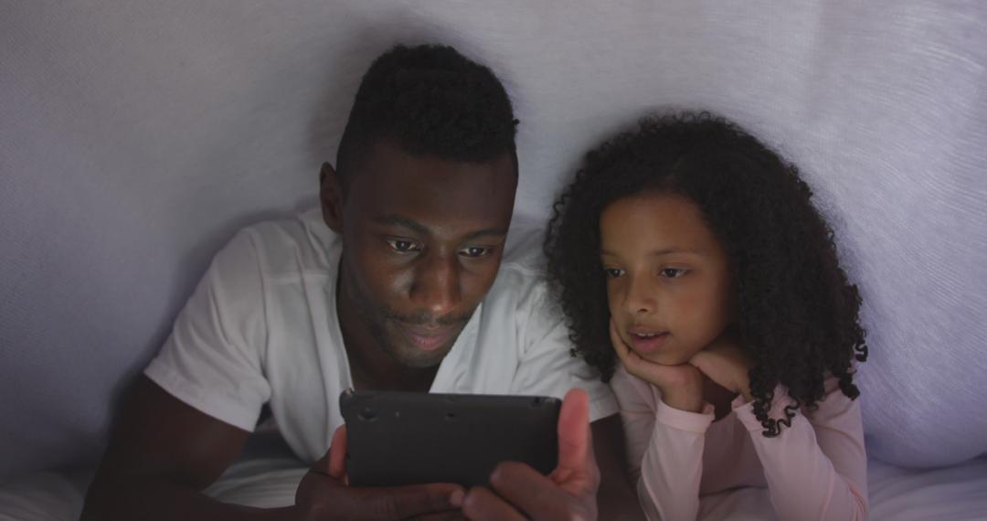 Father and Daughter Watching Tablet Under Blanket - Free Images, Stock Photos and Pictures on Pikwizard.com