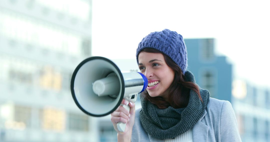 Young Woman Using Megaphone Outdoors Wearing Knit Hat and Scarf - Free Images, Stock Photos and Pictures on Pikwizard.com