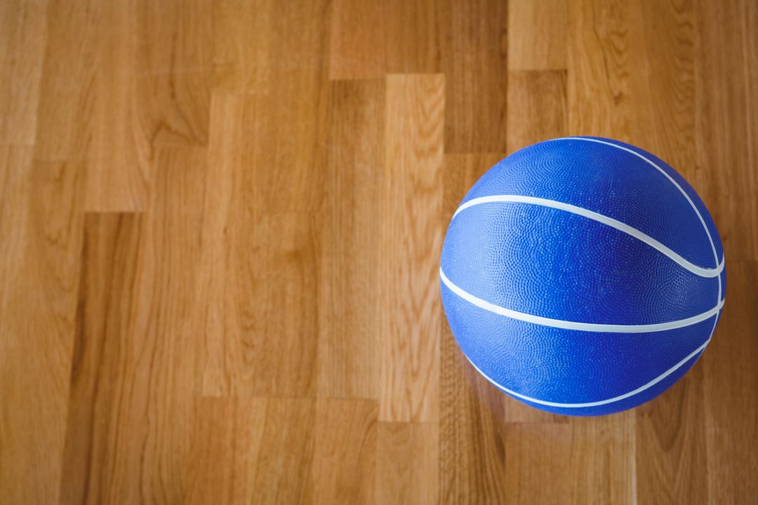 Overhead view of blue basketball on hardwood floor - Free Images, Stock Photos and Pictures on Pikwizard.com
