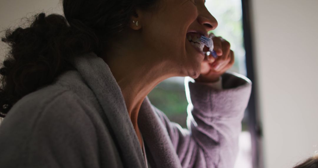 Woman Brushing Teeth in Soft Morning Light - Free Images, Stock Photos and Pictures on Pikwizard.com