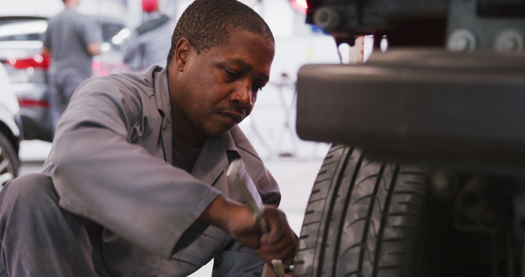 Mechanic Repairing Car Tire in Auto Shop - Free Images, Stock Photos and Pictures on Pikwizard.com