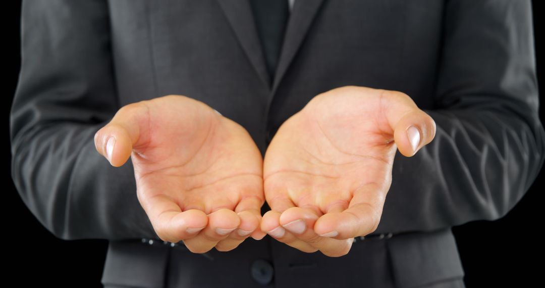 Close-Up of Businessman with Opened Hands on Dark Background