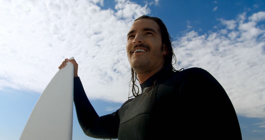 Young Man with Surfboard Enjoying Sunny Day at Beach - Free Images, Stock Photos and Pictures on Pikwizard.com