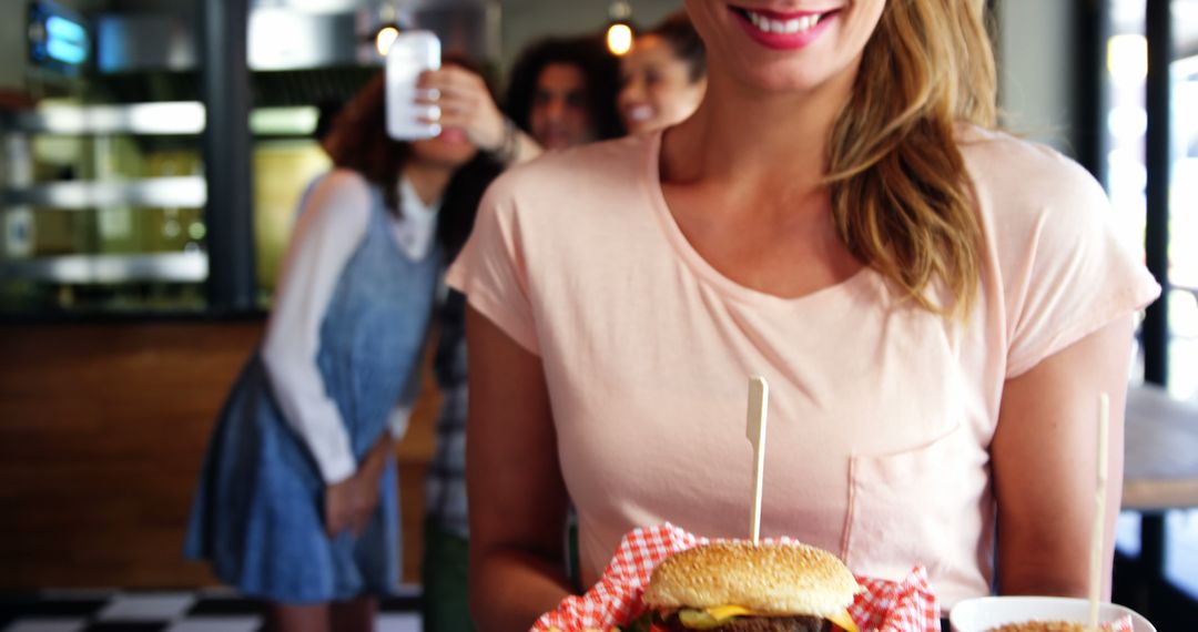 Woman Enjoying Burger at Diner with Friends Taking Selfies - Free Images, Stock Photos and Pictures on Pikwizard.com