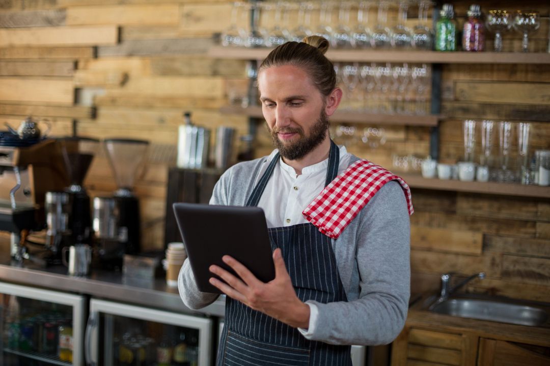 Waiter Uses Tablet in Trendy Cafe Environment