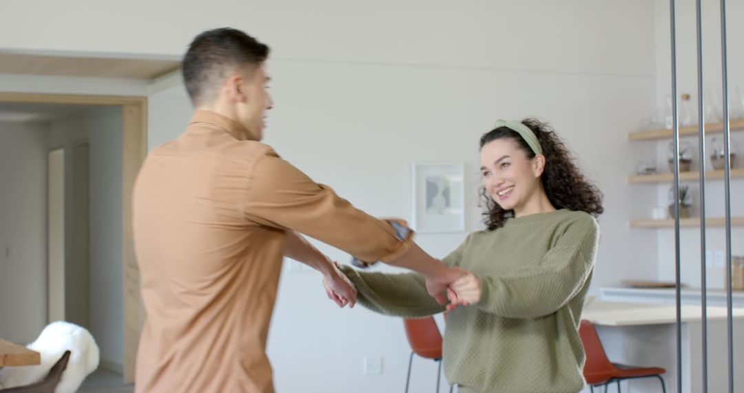 Playful Couple Dancing in Modern Dining Area