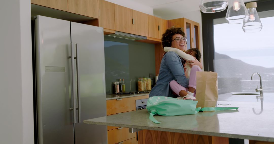 Joyful Mother Hugging Daughter in Modern Kitchen