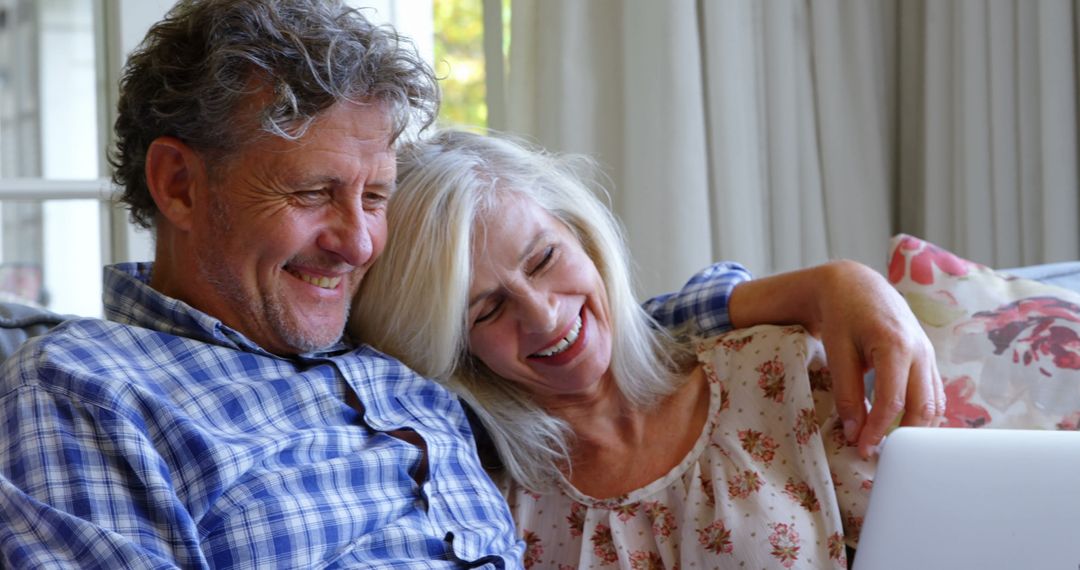 Happy Senior Couple Using Laptop at Home Relaxing Together