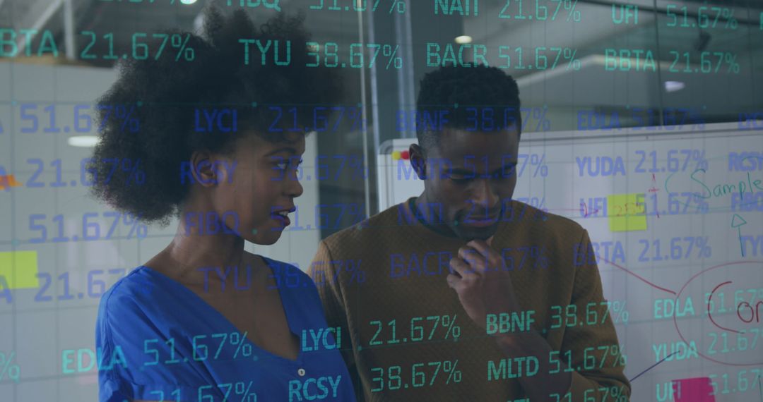 Diverse Colleagues Analyzing Stock Market Data in Modern Office