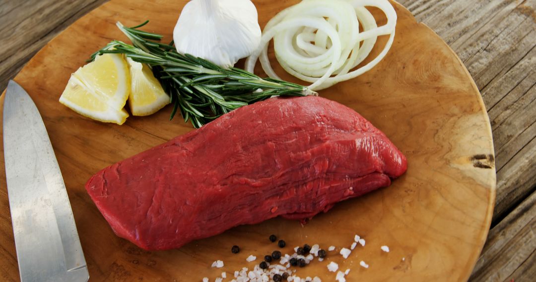 Preparing Fresh Beef Steak with Garlic, Onion, Lemon, and Rosemary - Free Images, Stock Photos and Pictures on Pikwizard.com