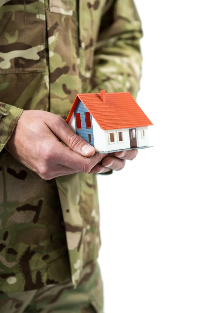 Mid section of soldier holding a model home - Free Images, Stock Photos and Pictures on Pikwizard.com