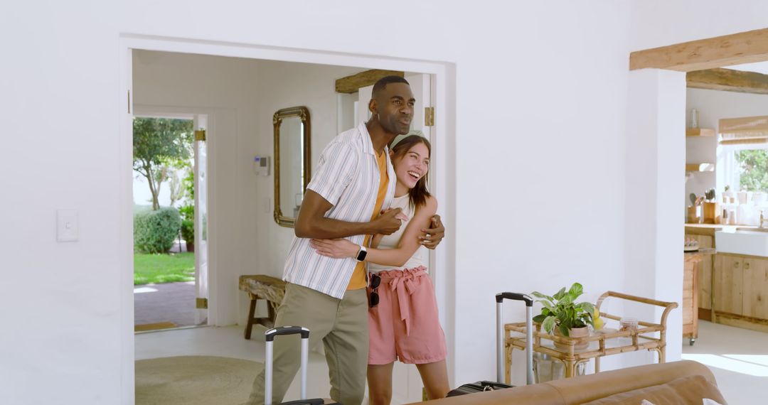 Joyful Couple Laughing in Modern Home Entryway with Luggage