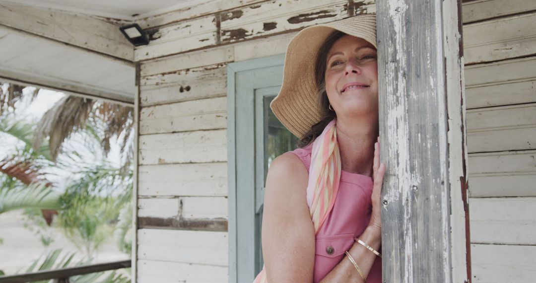 Middle-Aged Woman in Sun Hat Relaxing on Rustic Porch - Free Images, Stock Photos and Pictures on Pikwizard.com