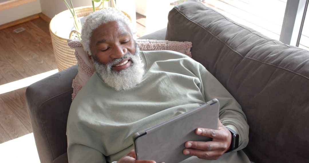 Senior Man Relaxed at Home with Tablet in Modern Living Space