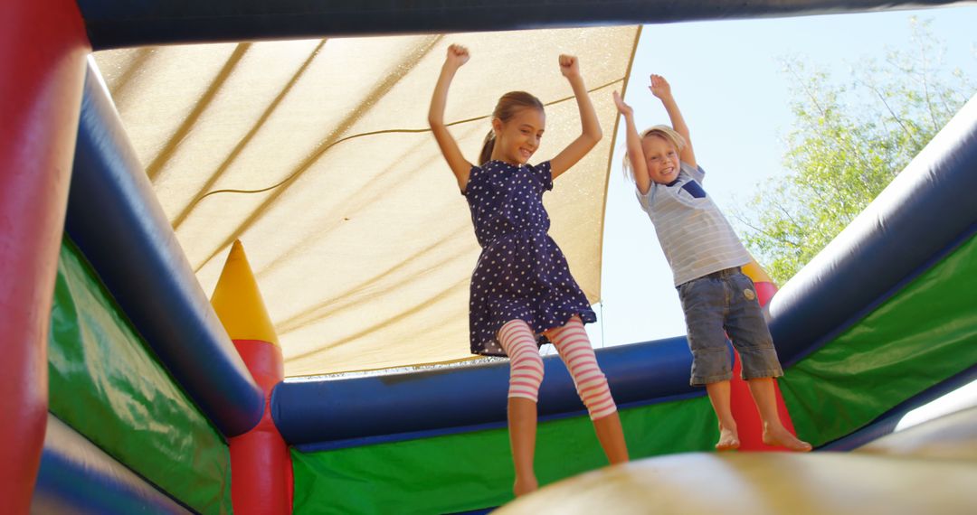 Children Having Fun on Colorful Bouncy Castle Outdoors - Free Images, Stock Photos and Pictures on Pikwizard.com