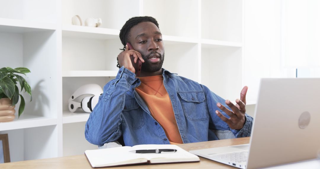 African American Man Talking on Smartphone While Working Remotely at Home Desk