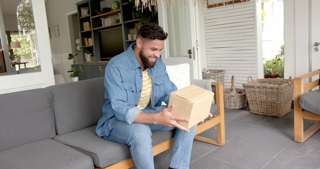 Smiling Man Unpacking Box on Cozy Patio with Wicker Baskets