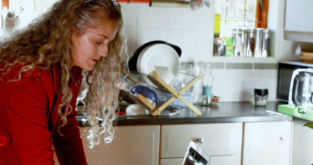 Woman Inspects Pot in Cozy Home Kitchen - Free Images, Stock Photos and Pictures on Pikwizard.com