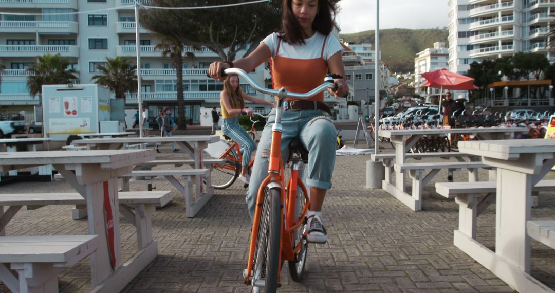 Young Women Riding Bicycles in Urban Park - Free Images, Stock Photos and Pictures on Pikwizard.com