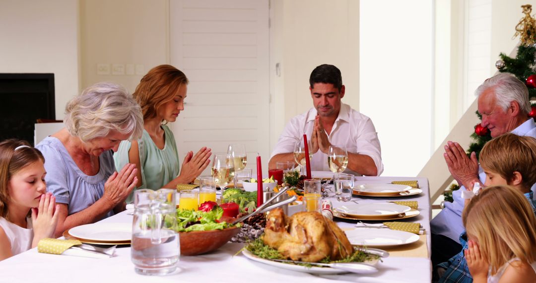 Family Praying Together During Festive Holiday Meal - Free Images, Stock Photos and Pictures on Pikwizard.com