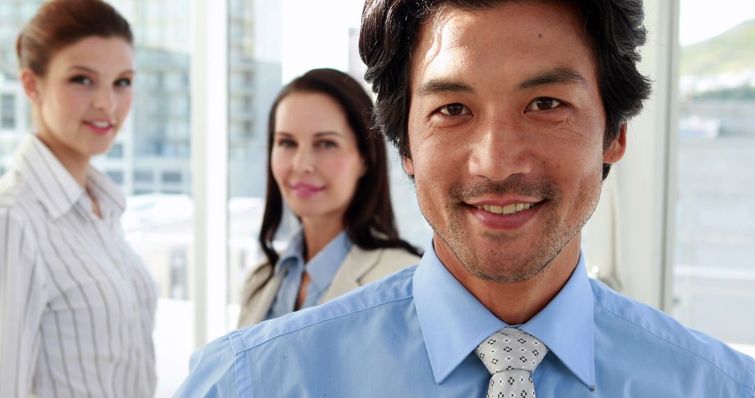 Confident Businessman Smiling with Diverse Colleagues in Office - Free Images, Stock Photos and Pictures on Pikwizard.com