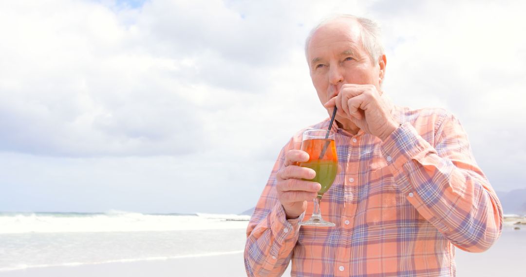 Senior Man Enjoying Refreshing Drink on Beach Vacation - Free Images, Stock Photos and Pictures on Pikwizard.com