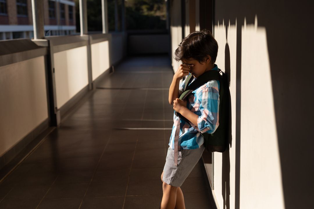 Content Young Boy Reflecting in Sunlit Corridor