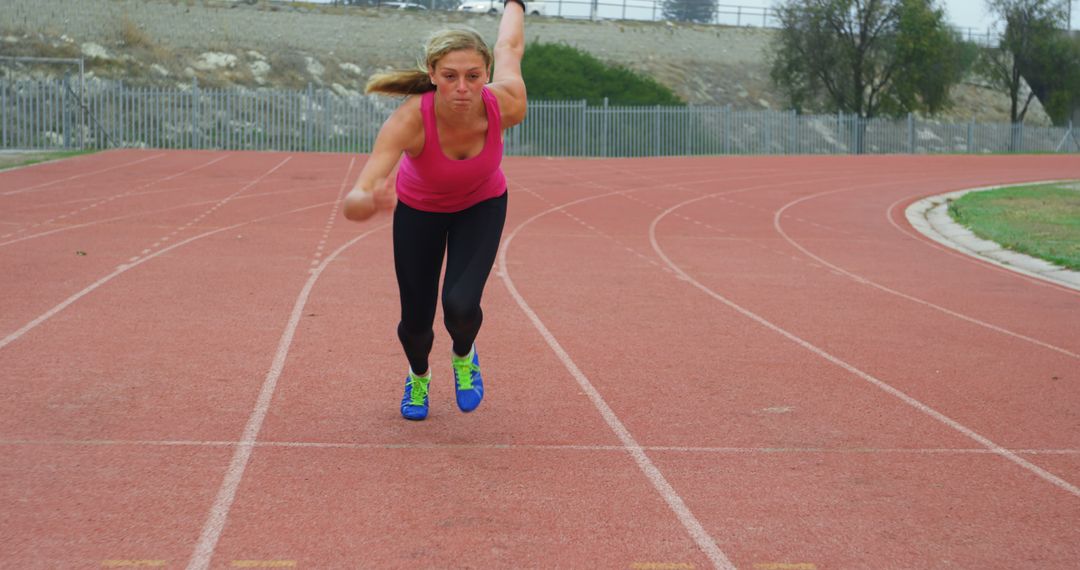 Female Athlete Starting Sprint on Track in Vibrant Workout Gear - Free Images, Stock Photos and Pictures on Pikwizard.com