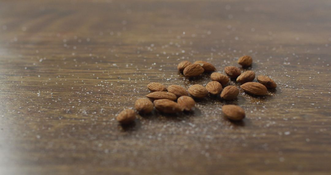 Almonds Scattered on Wooden Surface with Salted Texture