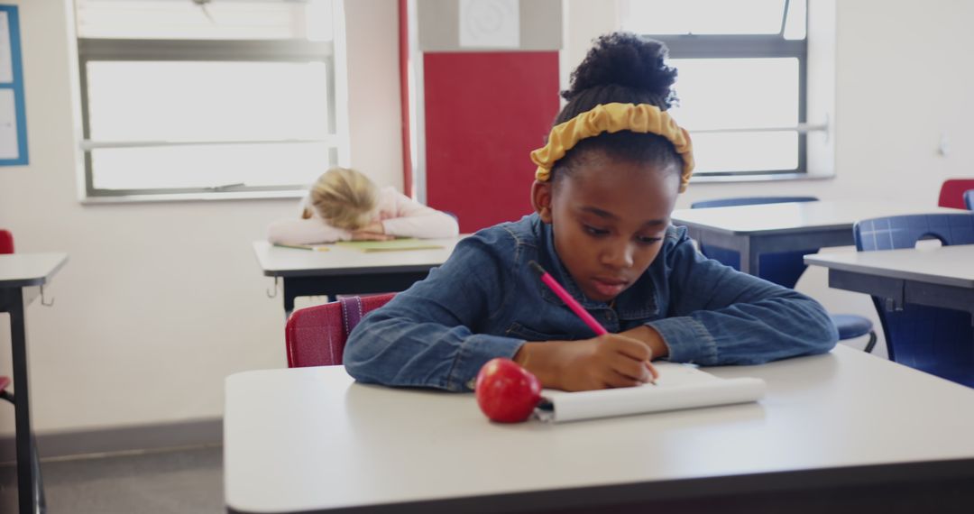 Young Student Engaging in Classroom Writing