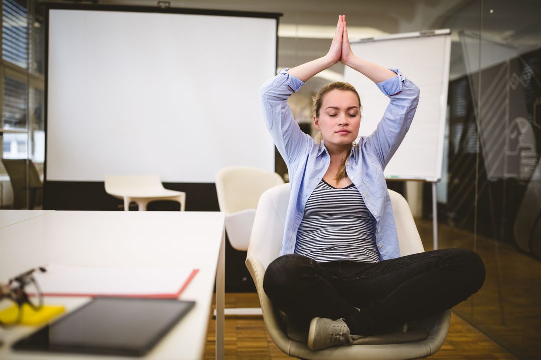 Businesswoman performing yoga in meeting room - Free Images, Stock Photos and Pictures on Pikwizard.com