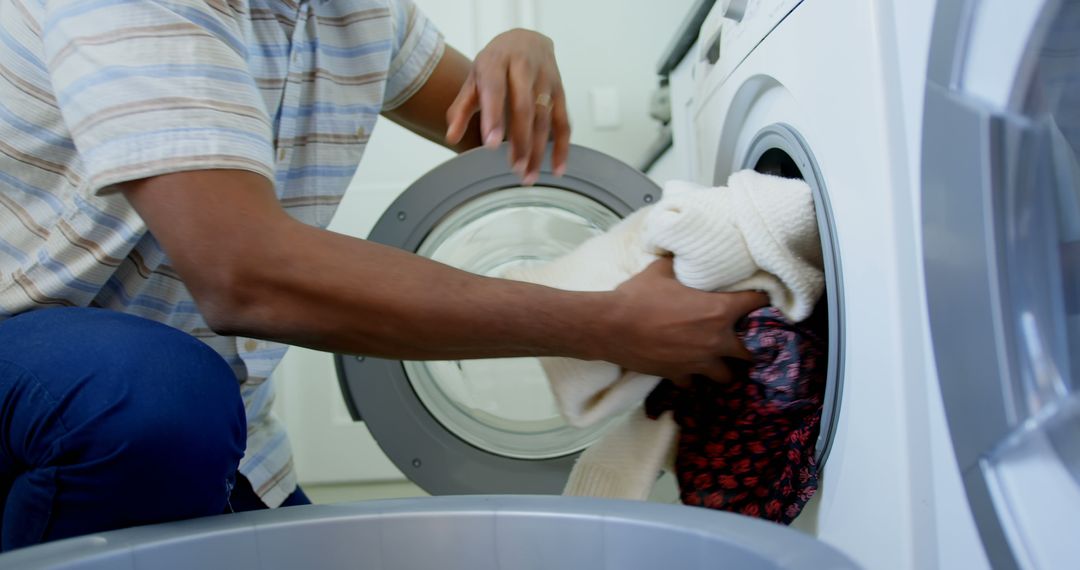 Man Loading Laundry into Washing Machine in Modern Home Laundry Room - Free Images, Stock Photos and Pictures on Pikwizard.com