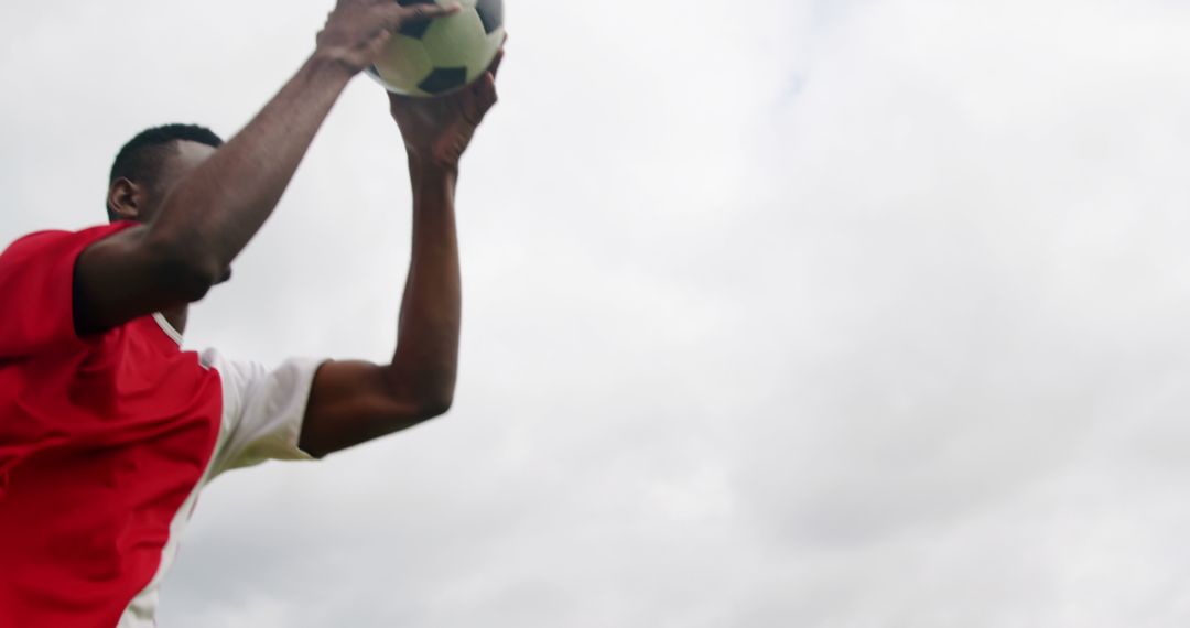 Soccer Player Throwing Ball Under Cloudy Sky - Free Images, Stock Photos and Pictures on Pikwizard.com