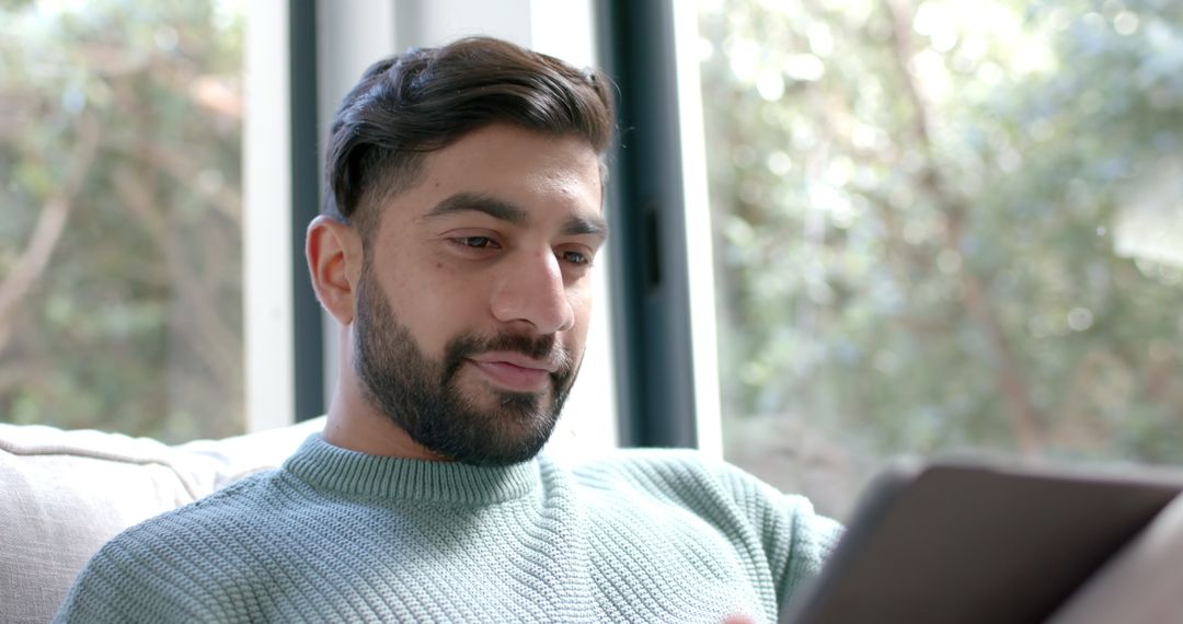 Young Man Shopping Online with Tablet at Home