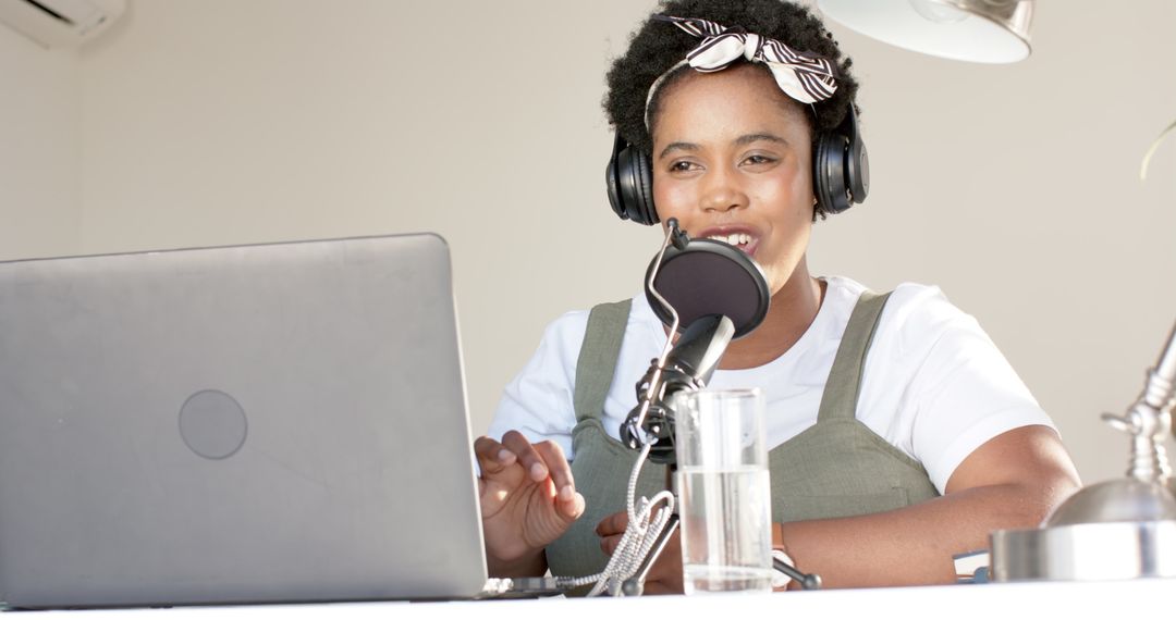 Engaged Young Woman Podcasting at Home with Microphone and Laptop
