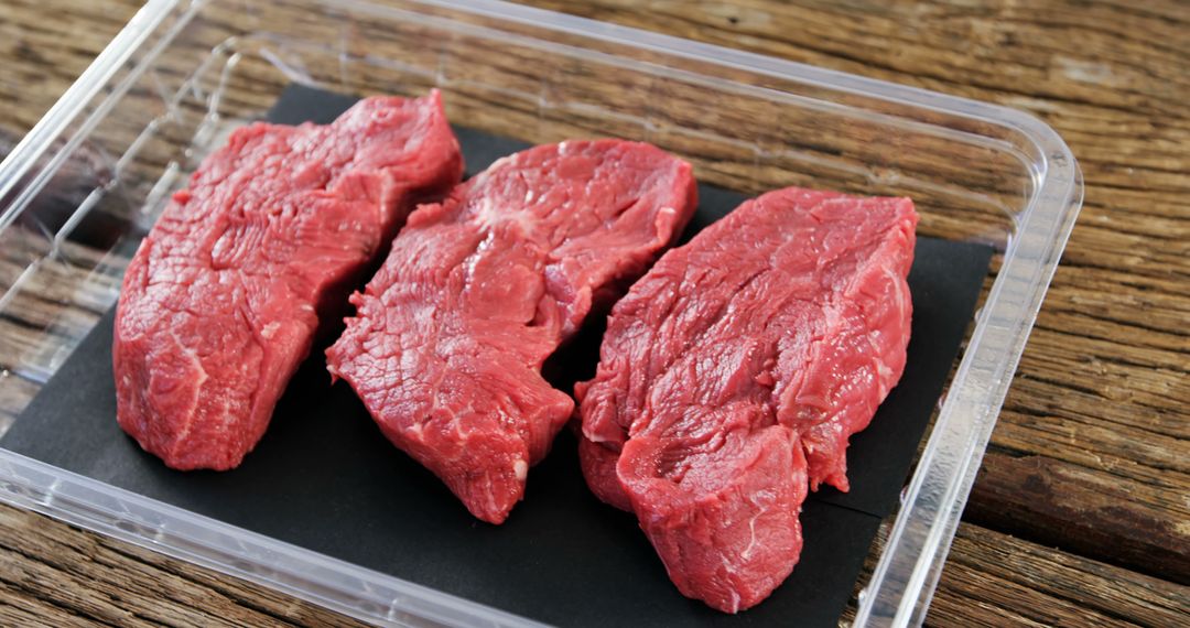 Fresh Raw Steak Meat on Plastic Tray on Wooden Table - Free Images, Stock Photos and Pictures on Pikwizard.com