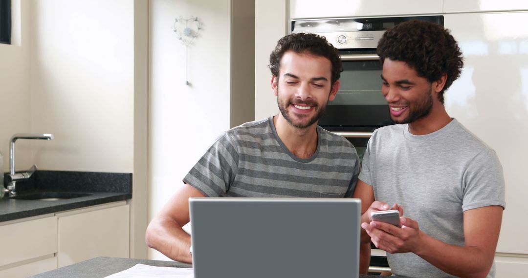 Collaborative Men Using Laptop and Smartphone in Modern Kitchen