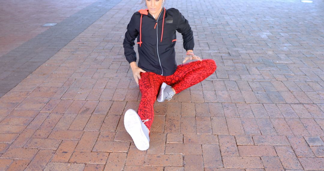 Man Stretching Legs on Brick Floor in Red Athletic Wear - Free Images, Stock Photos and Pictures on Pikwizard.com