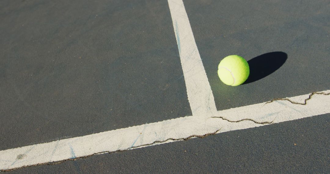 Tennis Ball on Cracked Hardcourt with Shadow - Free Images, Stock Photos and Pictures on Pikwizard.com