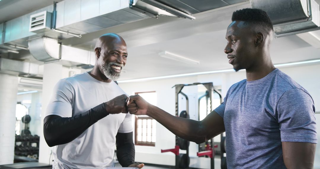 Trainer and Client Fist Bump in Gym for Teamwork and Motivation