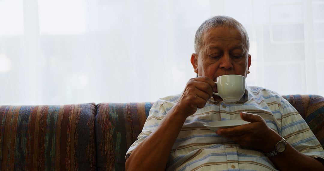 Elderly Man Enjoying Hot Beverage on Sofa - Free Images, Stock Photos and Pictures on Pikwizard.com