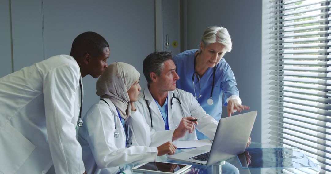 Diverse Medical Team Collaborating on Laptop in Bright Office - Free Images, Stock Photos and Pictures on Pikwizard.com