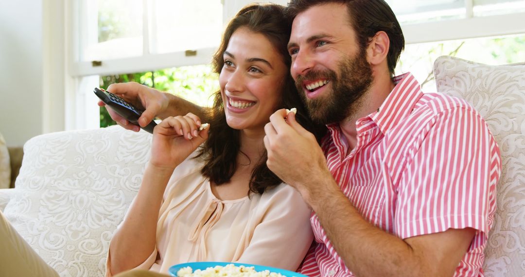 Happy Couple Enjoying Movie Night at Home with Popcorn - Free Images, Stock Photos and Pictures on Pikwizard.com