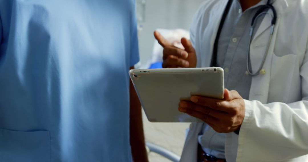 Doctor consulting with nurse using tablet in hospital - Free Images, Stock Photos and Pictures on Pikwizard.com