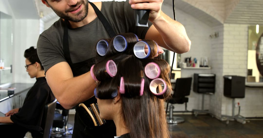 Hair Stylist Curling Client's Hair in Modern Salon - Free Images, Stock Photos and Pictures on Pikwizard.com