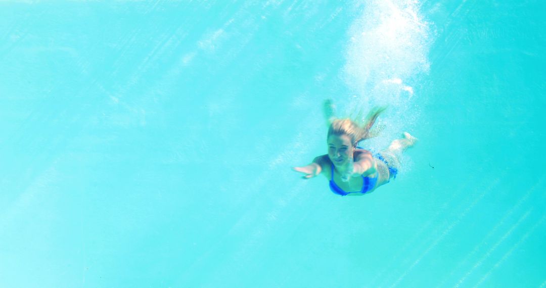 Woman Diving into Pool from Underwater View on Sunny Day
