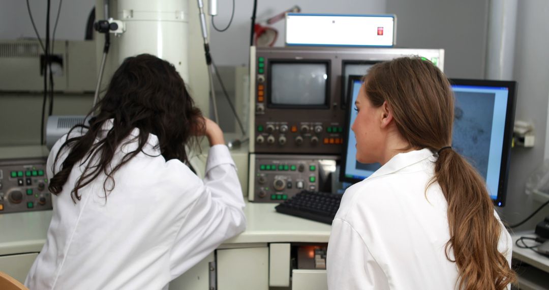 Researchers in lab coats operating advanced laboratory equipment - Free Images, Stock Photos and Pictures on Pikwizard.com