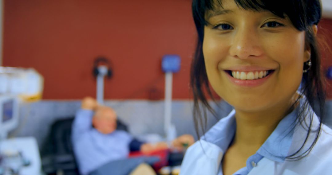 Smiling Healthcare Professional in Clinic, Patient in Background - Free Images, Stock Photos and Pictures on Pikwizard.com