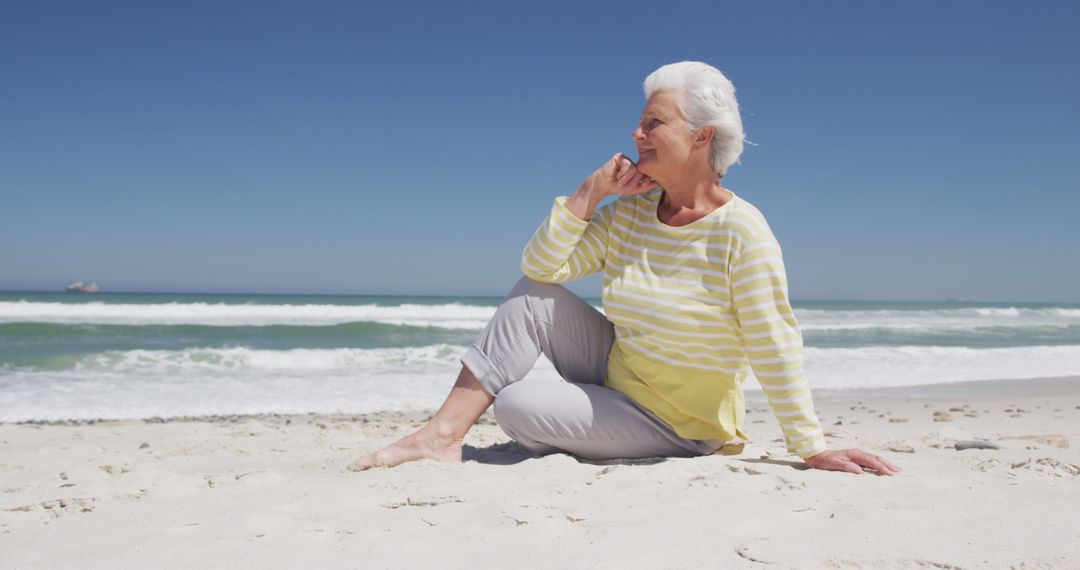 Senior Woman Relaxing on Sandy Beach on Sunny Day - Free Images, Stock Photos and Pictures on Pikwizard.com