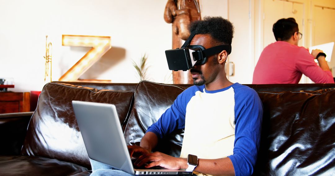 Man Using Virtual Reality Headset While Working on Laptop - Free Images, Stock Photos and Pictures on Pikwizard.com